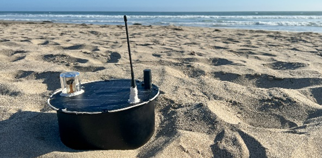 Hardware from the Ocean of Things program in sand on a beach.