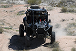 A RACER Fleet Vehicle demonstrating its ability to autonomously perform on a RACER course on representative terrain at Fort Irwin, Calif.
